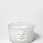 White scented candle in a glass jar with a centered Cedarwood & Rose label