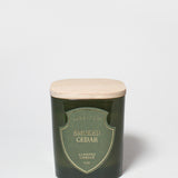 Smoked Cedar scented candle in a dark green glass vessel with a light wood lid.