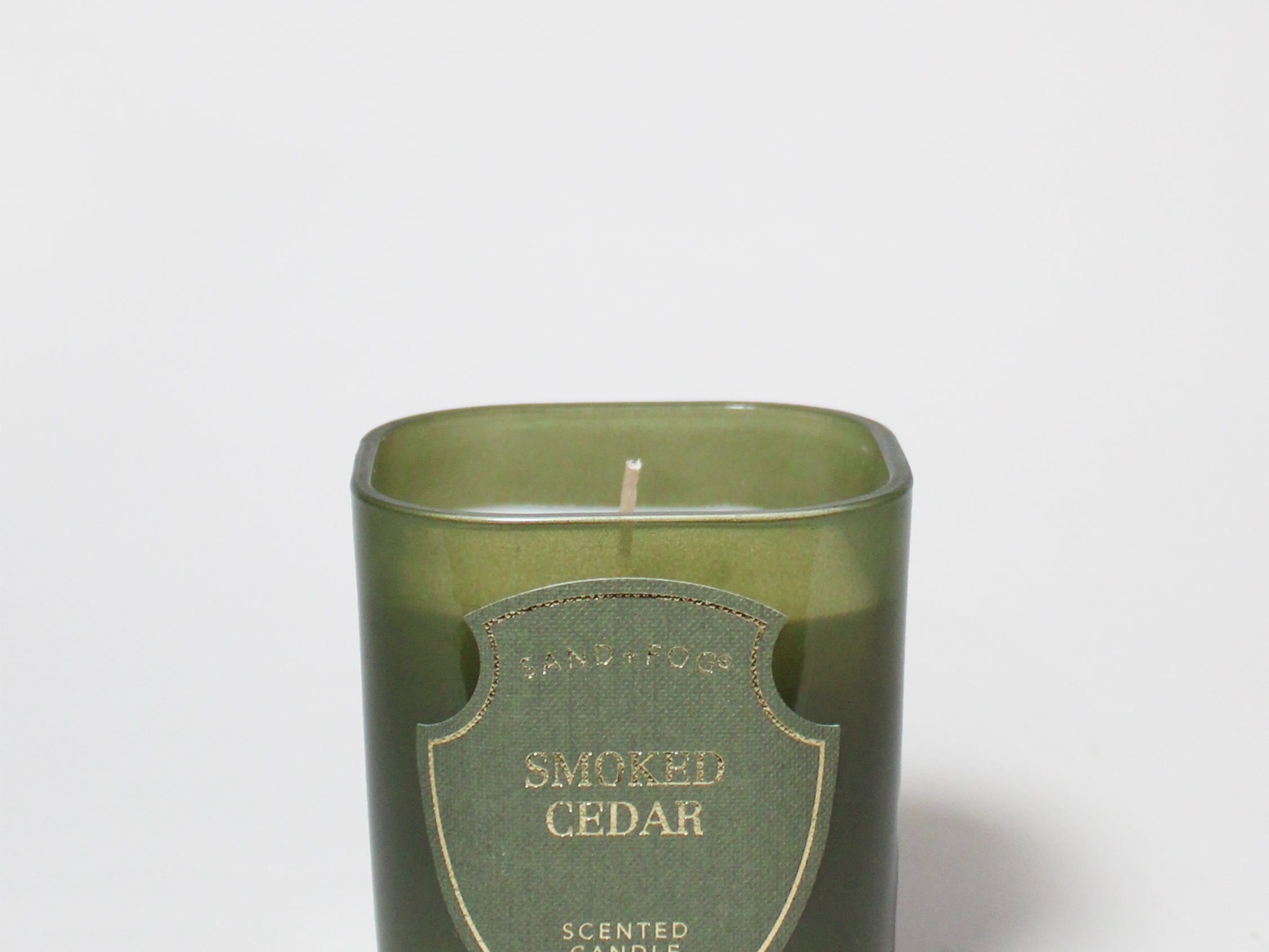 Smoked Cedar scented candle in a dark green glass vessel with a single wick.