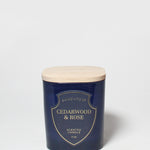 Cedarwood & Rose scented candle in a dark blue jar with a light wood lid