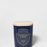 Cedarwood & Rose scented candle in a dark blue jar with a light wood lid