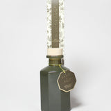 Bergamot and neroli reed diffuser in a dark green glass bottle with a patterned carton.