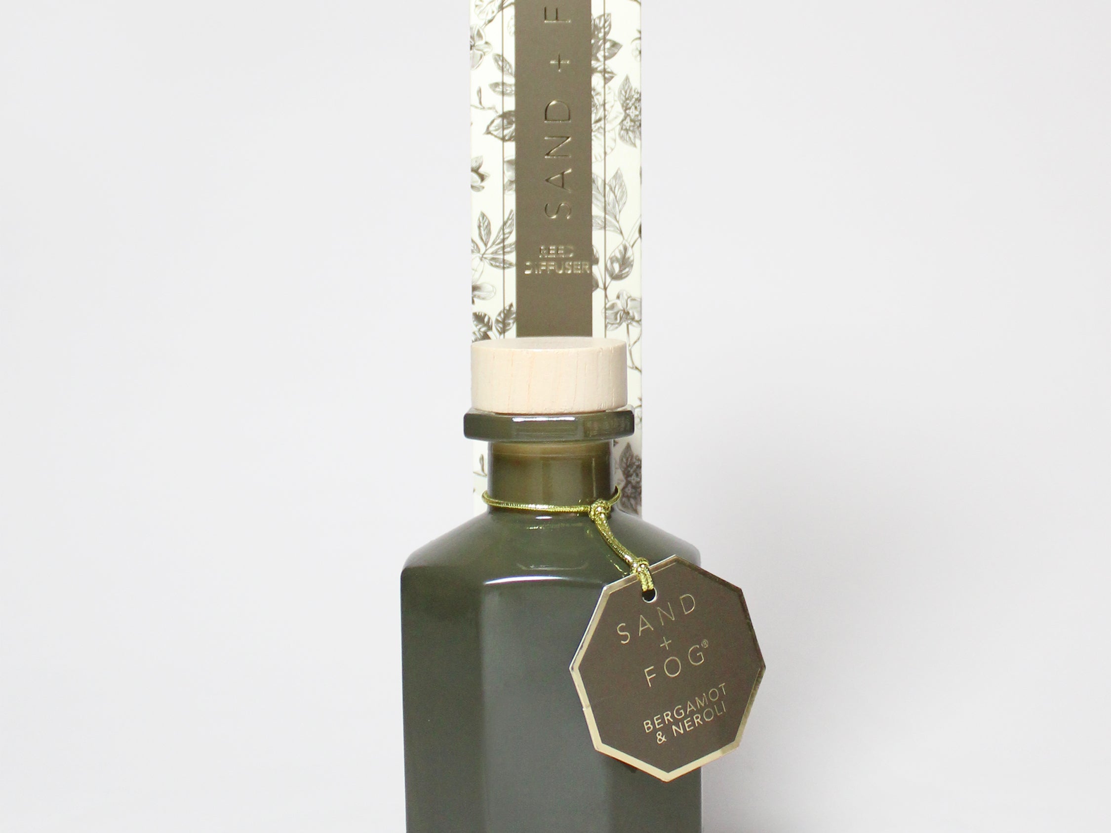 Bergamot and neroli reed diffuser in a dark green glass bottle with a patterned carton.