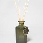Bergamot and neroli reed diffuser in a dark green glass bottle with four reeds.