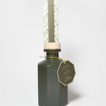 Forest & Ocean reed diffuser in a dark green glass bottle, topped with a clear protective tube