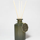 Forest & Ocean reed diffuser in a dark green glass bottle with four reeds and a hanging tag