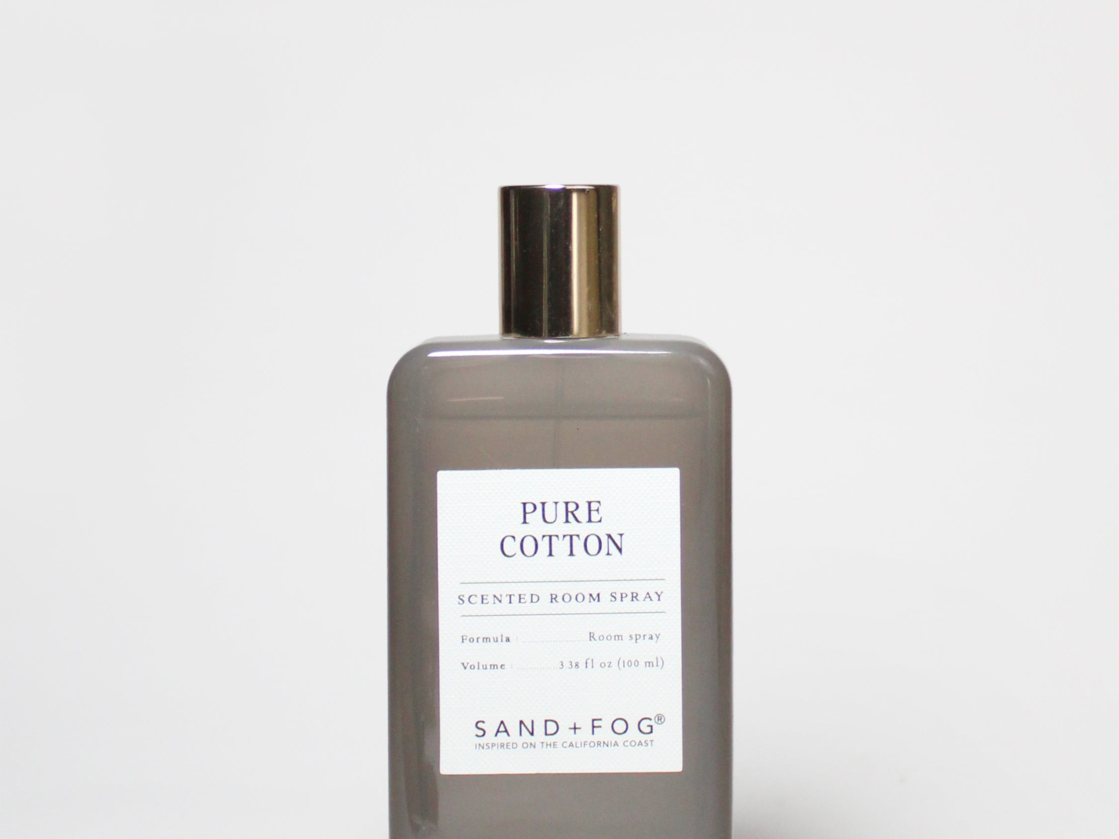 Frosted glass room spray bottle with gold cap and printed label