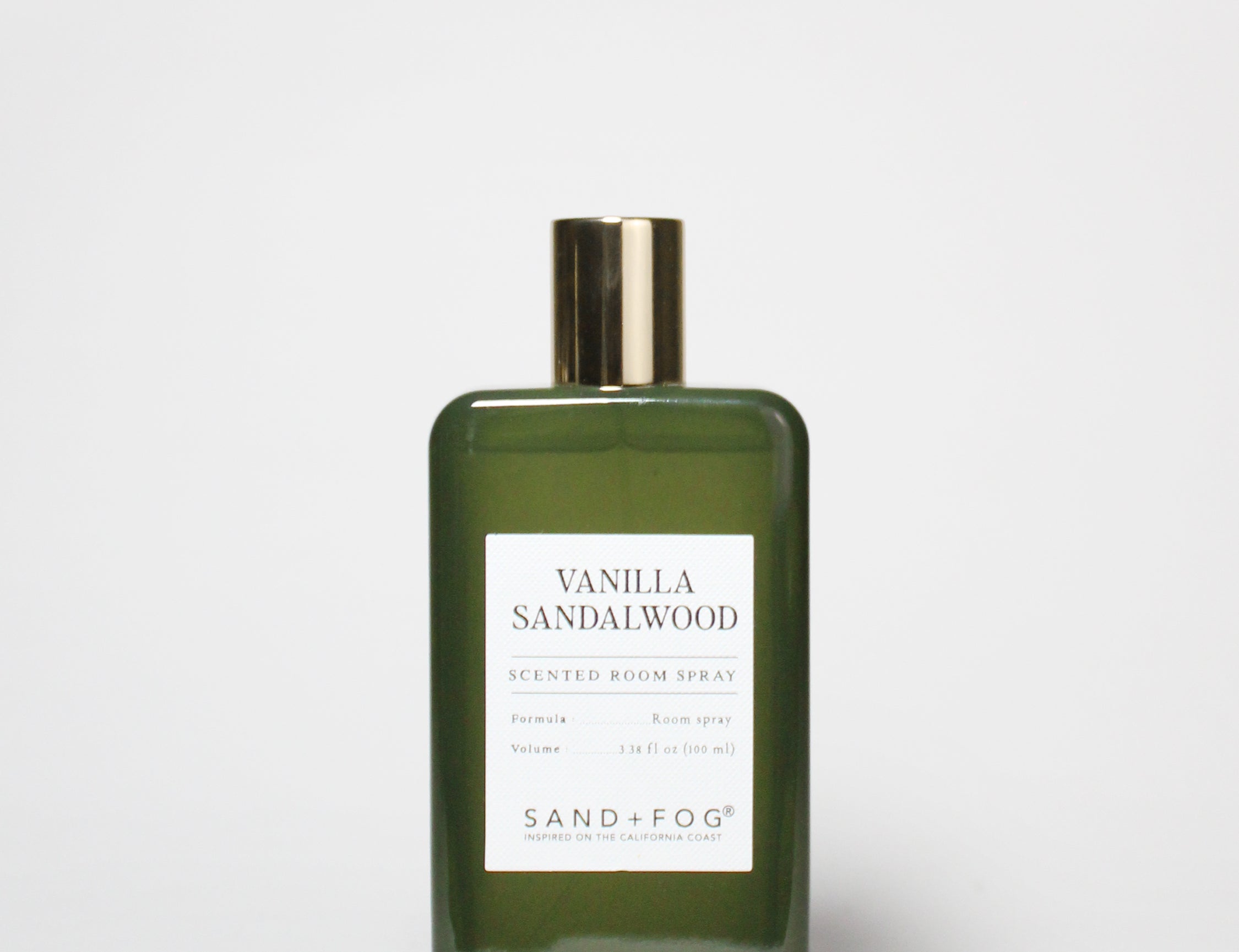 Green glass room spray bottle with gold cap and Vanilla Sandalwood label