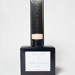 Vanilla sandalwood reed diffuser in a dark glass bottle with a light wood cap and box.