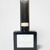 Vanilla sandalwood reed diffuser in a dark glass bottle with a light wood cap and box.