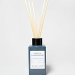 Vanilla Sandalwood reed diffuser in a blue glass bottle with reeds