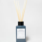Vanilla Sandalwood reed diffuser in a blue glass bottle with reeds