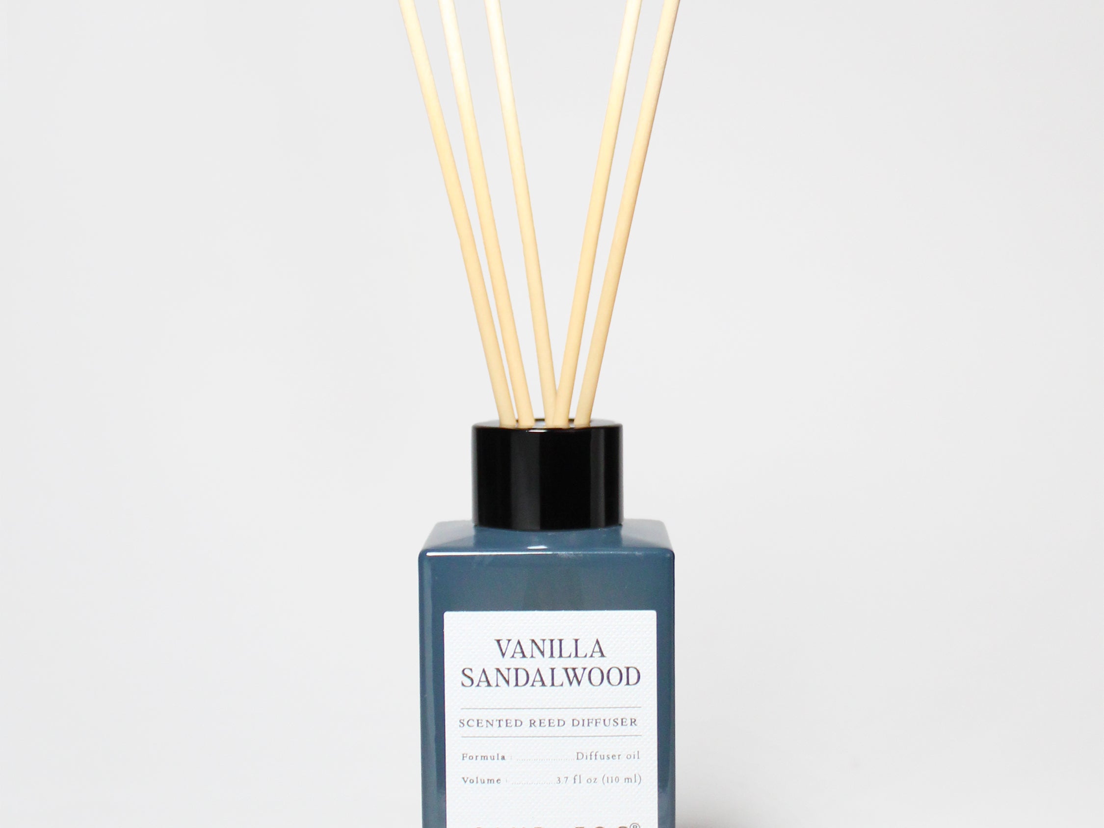 Vanilla Sandalwood reed diffuser in a blue glass bottle with reeds