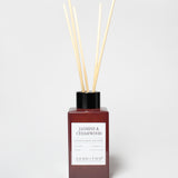 Jasmine & Cedarwood reed diffuser in a burgundy bottle with a black cap and several reeds.