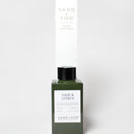 Sage & Citrus reed diffuser in a dark green glass bottle with a black cap and white label.