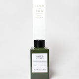 Sage & Citrus reed diffuser in a dark green glass bottle with a black cap and white label.