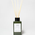Sage & Citrus reed diffuser in a dark green glass bottle with a black cap and five reeds.
