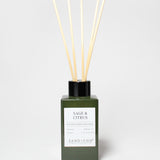 Sage & Citrus reed diffuser in a dark green glass bottle with a black cap and five reeds.