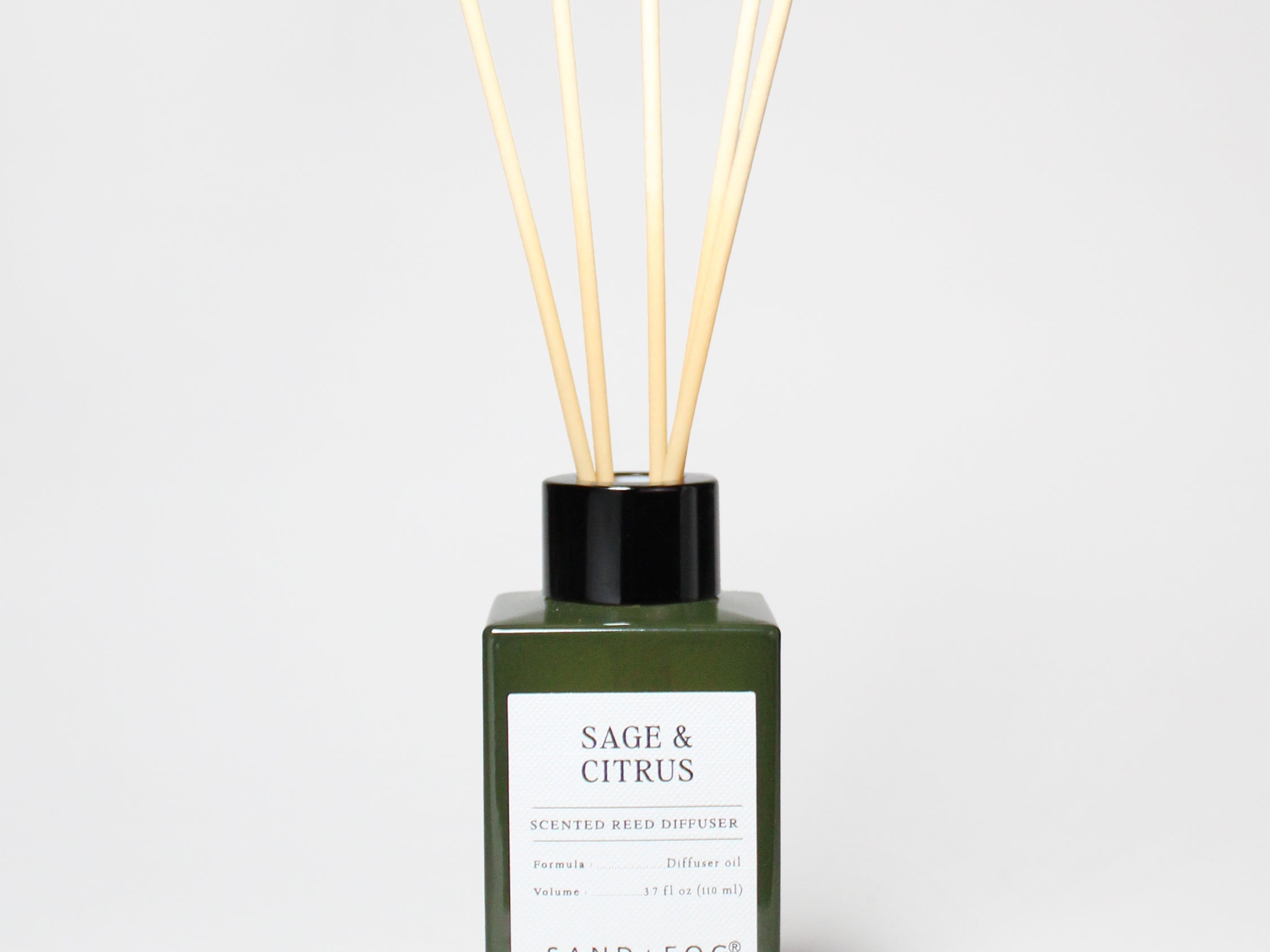 Sage & Citrus reed diffuser in a dark green glass bottle with a black cap and five reeds.