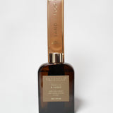 Vanilla and amber reed diffuser in an amber glass bottle with a tall gold-toned carton.