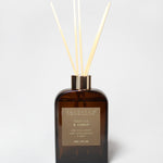 Vanilla and amber reed diffuser in a dark amber glass bottle with pale reeds.