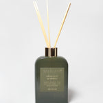 Bergamot and neroli reed diffuser in a dark green glass bottle with four reeds.