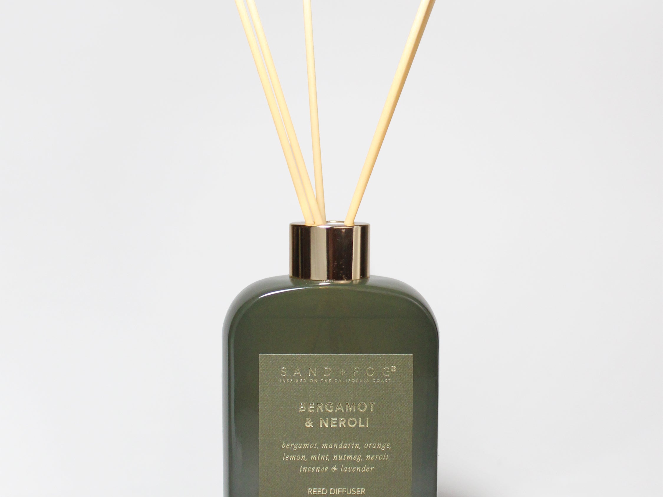 Bergamot and neroli reed diffuser in a dark green glass bottle with four reeds.