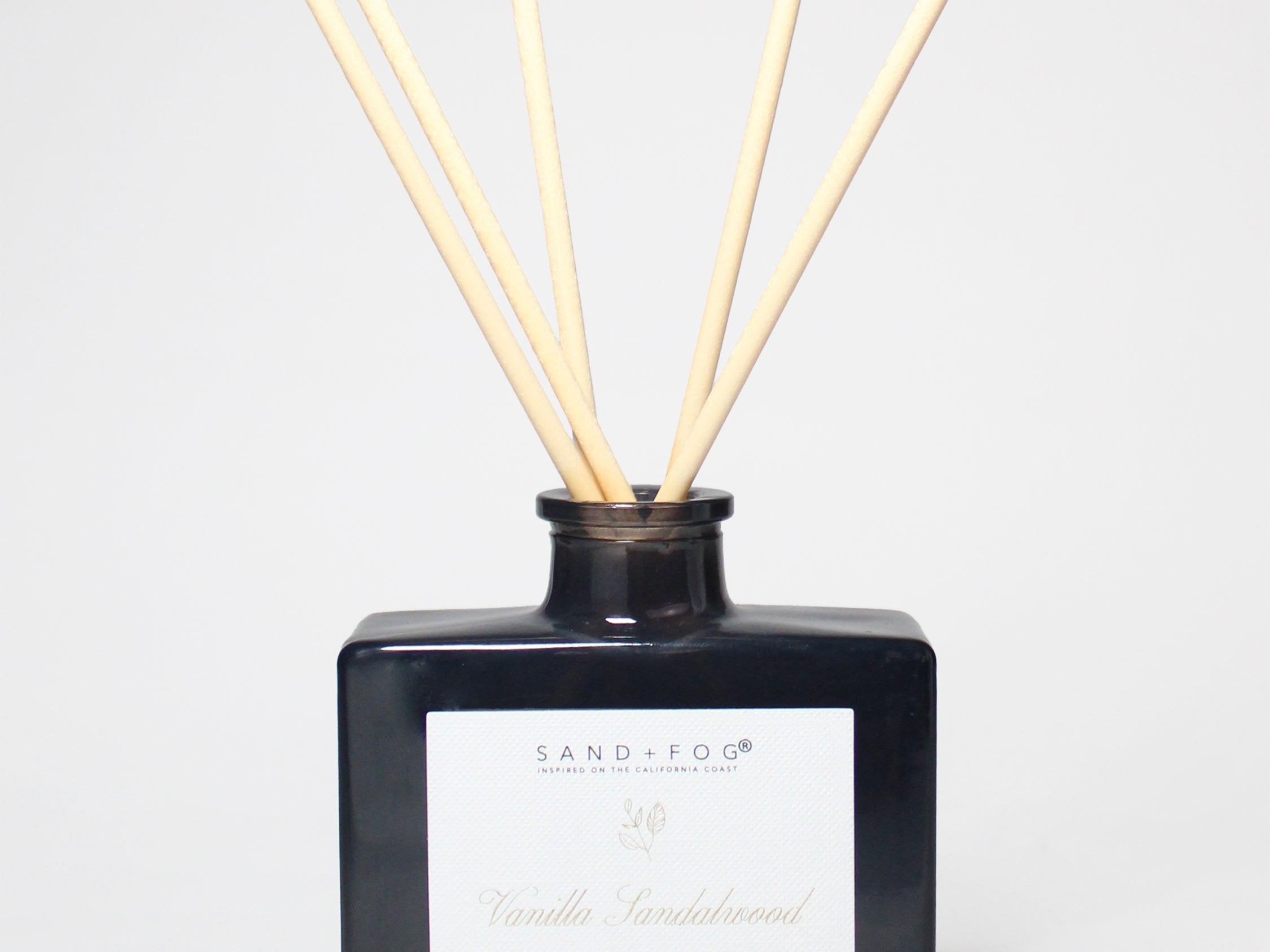 Vanilla sandalwood reed diffuser in a dark glass bottle with five natural reeds.