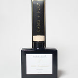 Violet Sandalwood reed diffuser in a dark square bottle with a light wood cap and matching box.