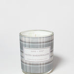 Salted Marshmallow scented candle in a clear glass jar with a gray plaid label and visible wick.