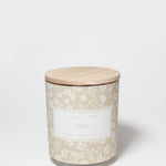 Eden 10 oz scented candle in a beige floral-patterned glass jar with a wooden lid.