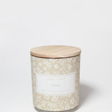 Eden 10 oz scented candle in a beige floral-patterned glass jar with a wooden lid.