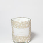 Eden 10 oz scented candle in a glass jar with a beige floral pattern and visible white wax.