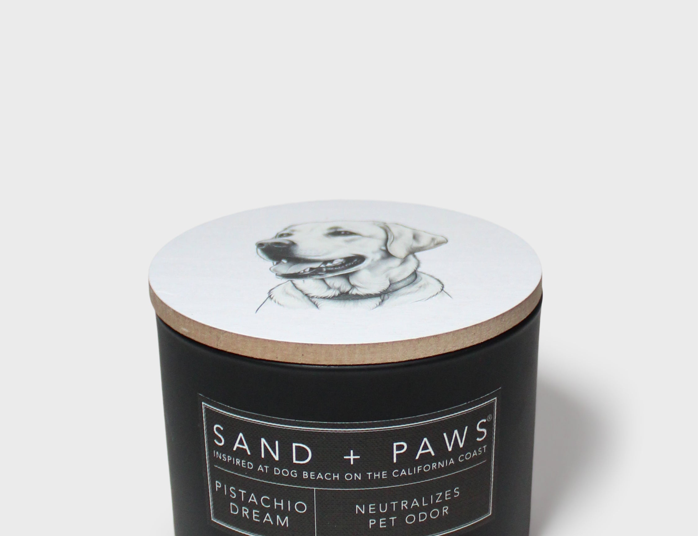 Sand + Paws 12 oz scented candle with dog sketch on lid and label