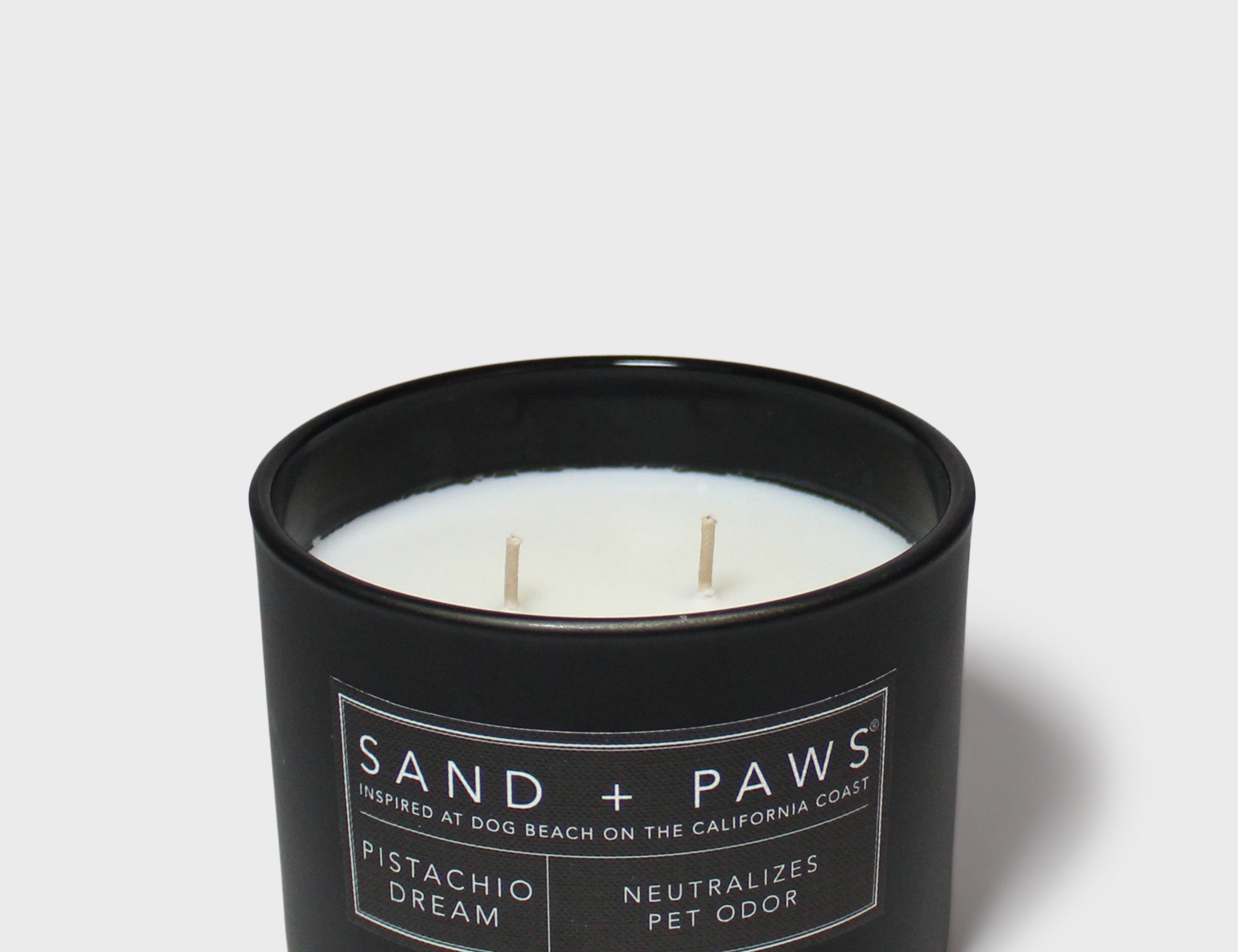 Sand + Paws 12 oz scented candle in black jar with label and three wicks