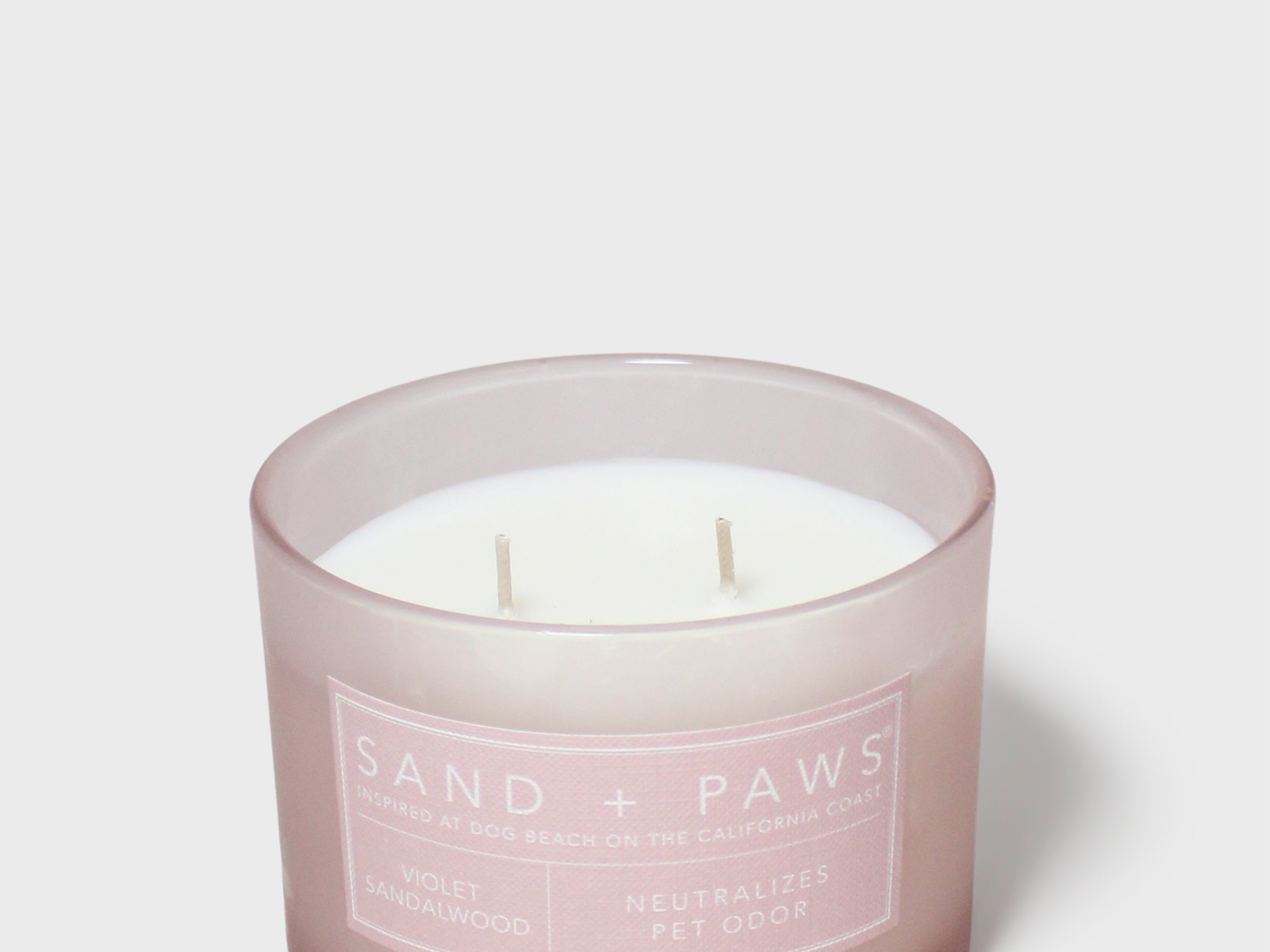 Scented candle in frosted glass jar with Sand + Paws label and three wicks