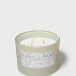 Amber Skies scented candle in frosted glass, Sand + Paws label on jar