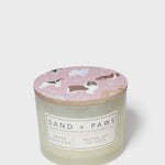 Scented candle with pink dog-print lid and Sand + Paws label