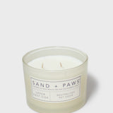 Scented candle in clear jar with Sand + Paws label and twin wicks
