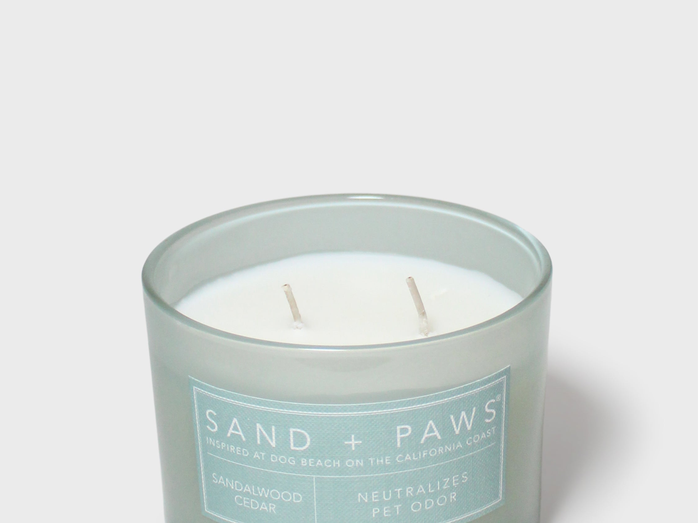 Scented candle in frosted light-blue jar with two wicks and label