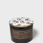Scented candle in dark glass jar with Sand + Paws label and printed dog lid