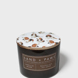 Scented candle in dark glass jar with Sand + Paws label and printed dog lid
