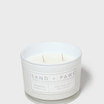 Scented candle in white glass jar with two wicks and orange vanilla label
