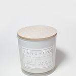 Scented candle with speckled beige lid and white label on jar
