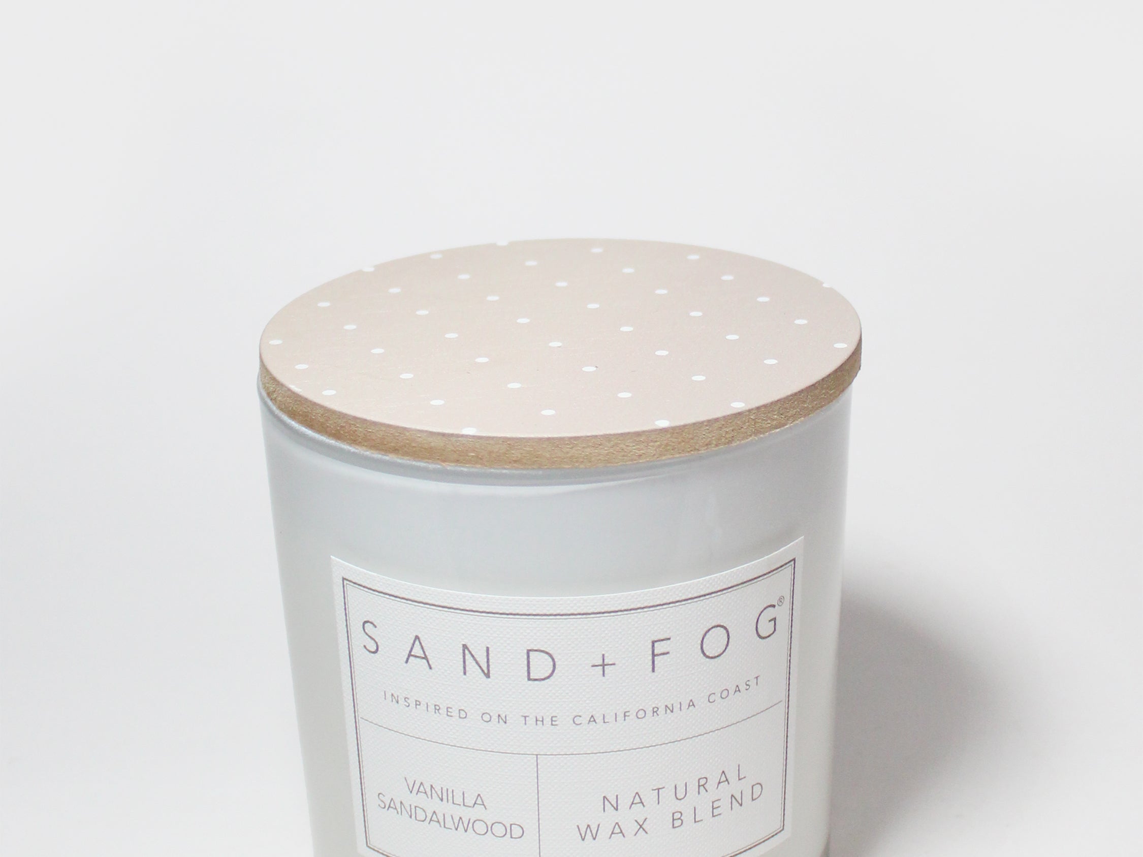 Scented candle with speckled beige lid and white label on jar