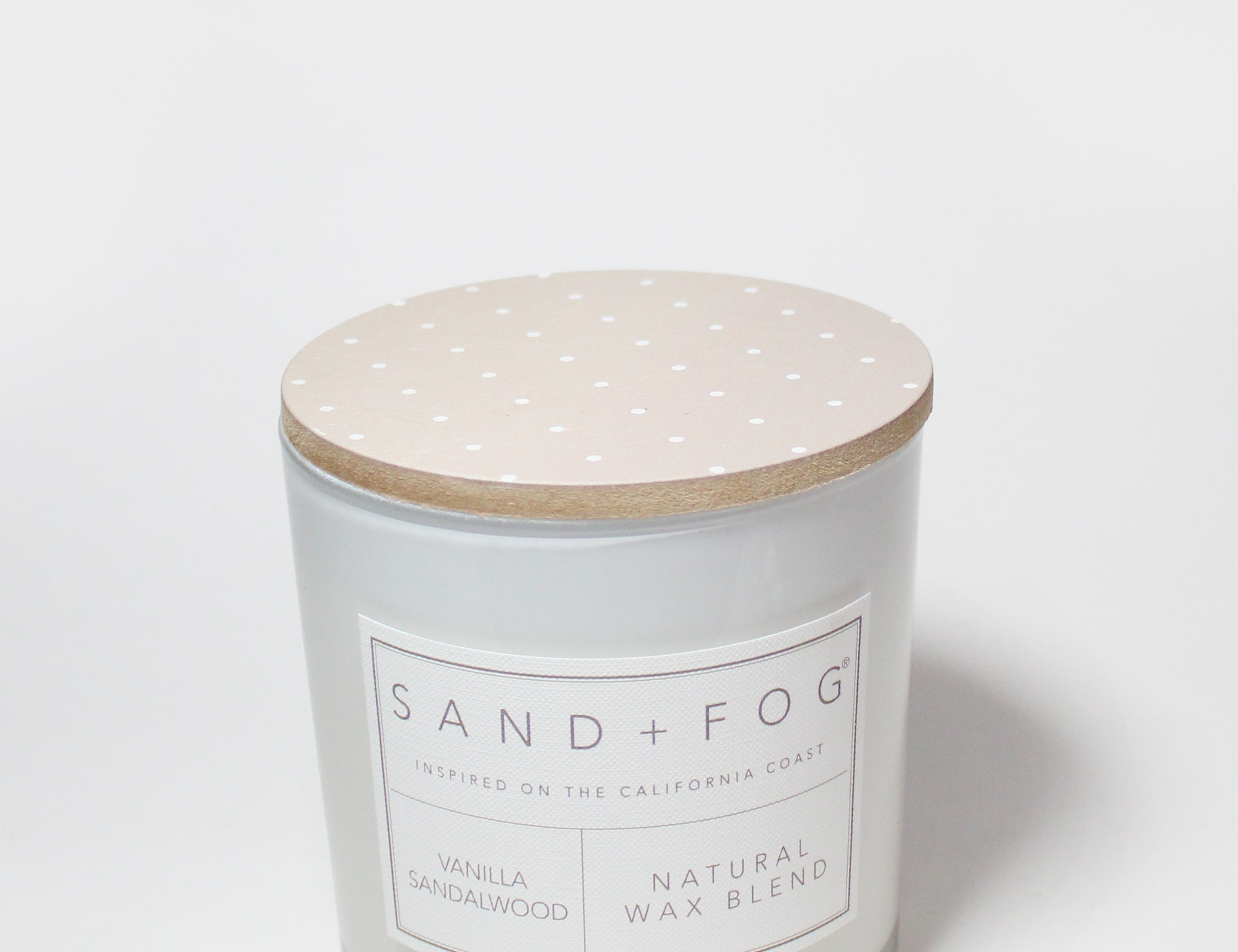 Scented candle with speckled beige lid and white label on jar