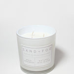 Vanilla sandalwood scented candle in white jar with label; natural wax blend