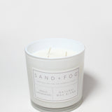 Vanilla sandalwood scented candle in white jar with label; natural wax blend