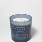 21 oz scented candle in dark blue glass jar with three wicks and label