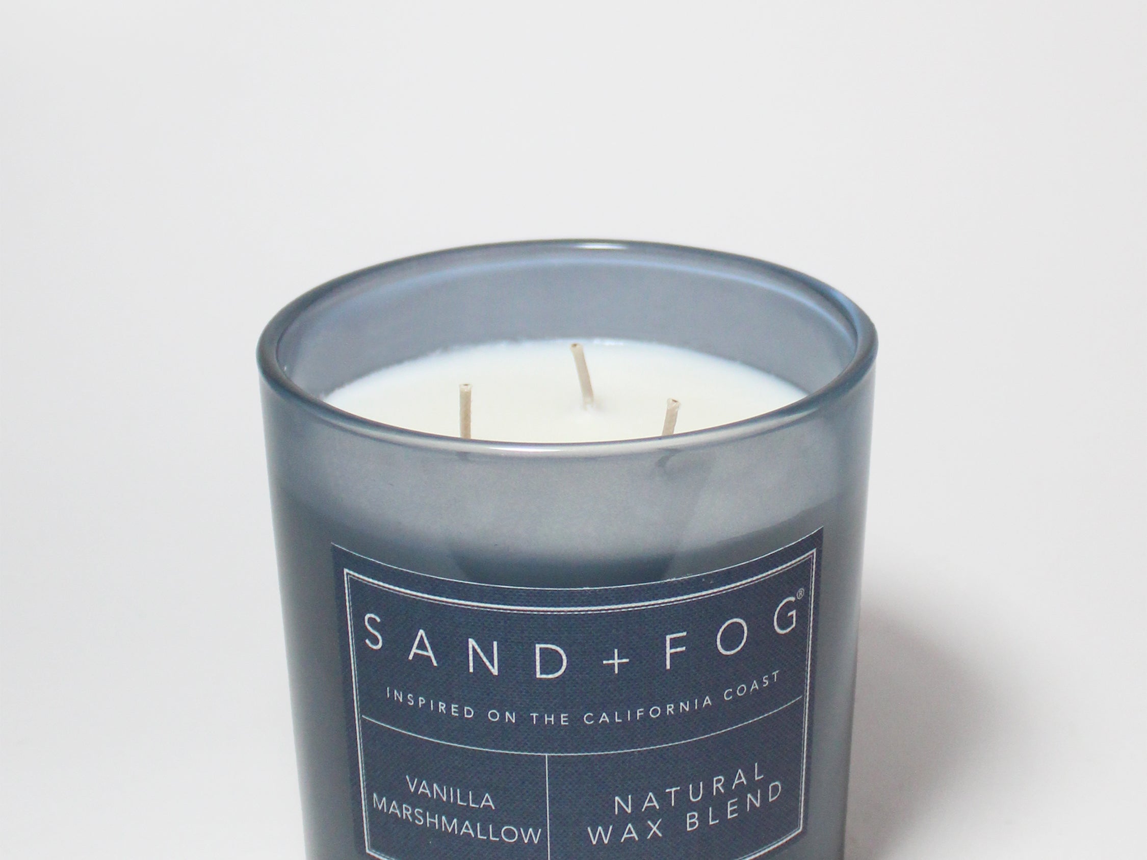 21 oz scented candle in dark blue glass jar with three wicks and label